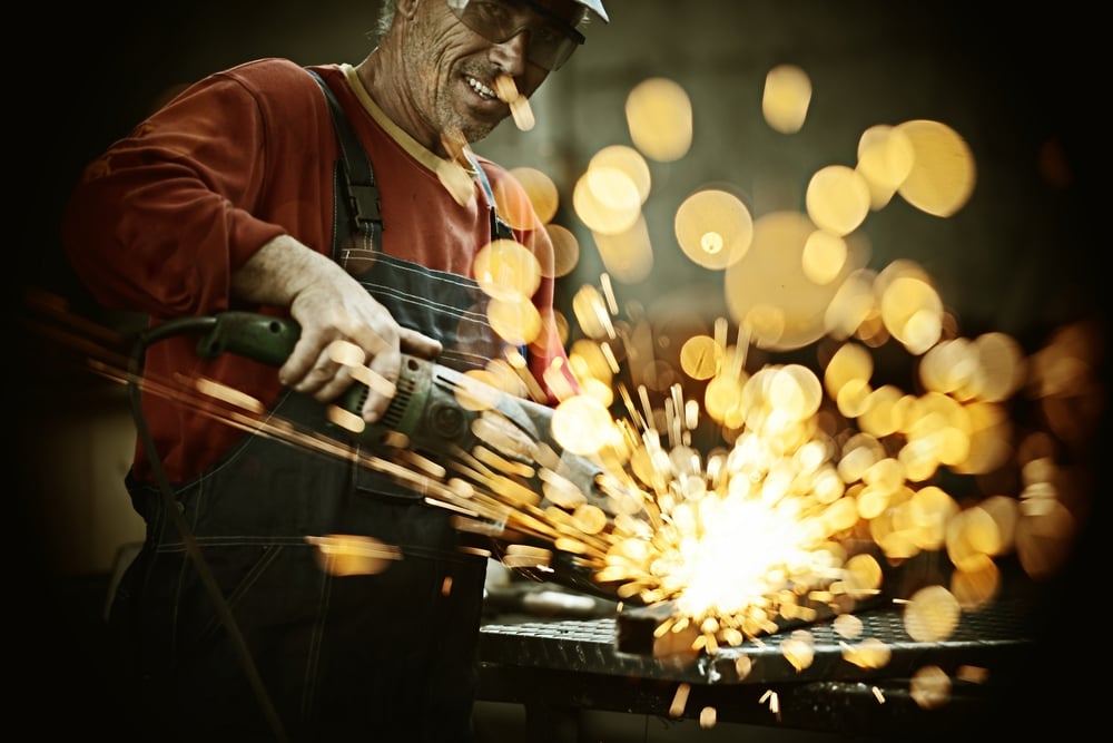 Industrial worker cutting and welding metal with many sharp sparks Industrial worker cutting and welding metal with many sharp sparks